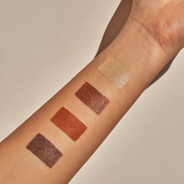 Swatches of four bronze and neutral shades from the Manifest Bronze Eyeshadow Palette | Chella applied on a forearm against a neutral background.