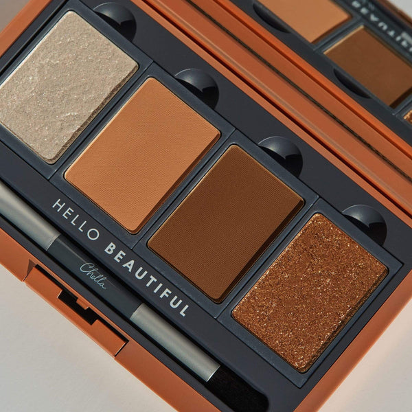 Close-up of La Vie Neutral Eyeshadow Palette | Chella featuring four warm neutral shades from light shimmer to deep matte brown with an applicator brush inside an orange compact.