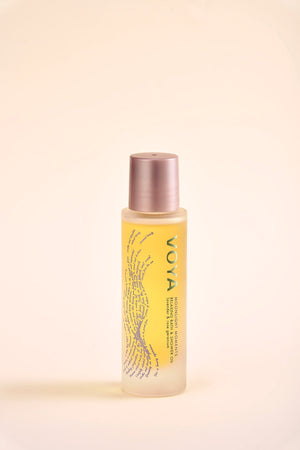 Bottle of Moonlight Moments Bath & Shower Oil | VOYA with golden-yellow oil inside, featuring a minimalist design and soft rose gold cap for skincare and body care wellness.