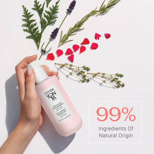 Hand holding a pink bottle of Lotion YON-KA PS | YON-KA surrounded by natural botanical elements and text highlighting 99% ingredients of natural origin for skincare.