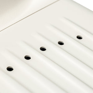 Close-up of a white panel with multiple small black openings designed as part of the SUMSEI Air Shower | SUMSEI, a wellness device for improved skincare and body care routines.
