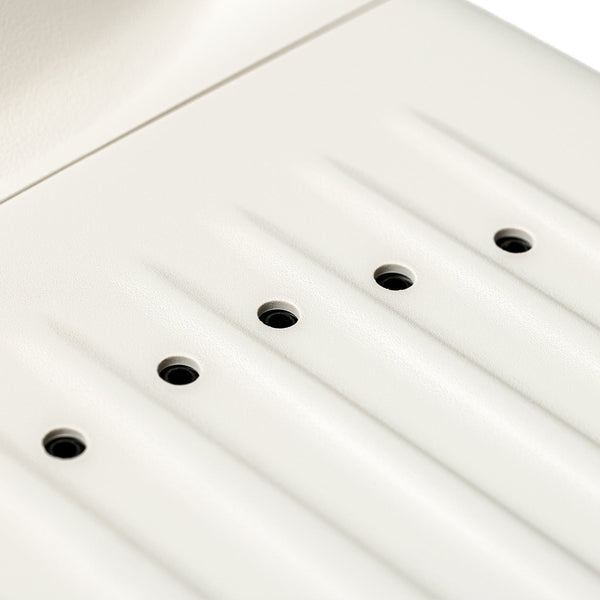 Close-up of a white panel with multiple small black openings designed as part of the SUMSEI Air Shower | SUMSEI, a wellness device for improved skincare and body care routines.