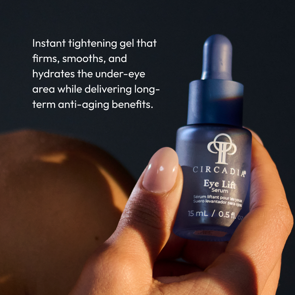 Hand holding a blue frosted glass dropper bottle of Eye Lift Serum (formerly Emergency Eye Lift) | Circadia with text describing it as an instant tightening gel that firms, smooths, and hydrates the under-eye area while delivering long-term anti-aging benefits.