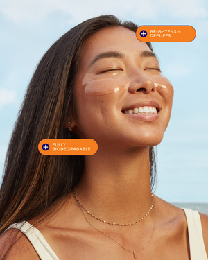 Smiling woman with clear skin wearing Brighter Days Red Algae + Avocado Biodegradable Eye Masks | Three Ships under her eyes, highlighting brightening and depuffing skincare benefits.