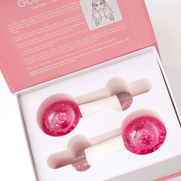 Open box showing two pink Glow Globes [Ice Roller for Face] | Dreambox Beauty with textured handles designed for facial skincare and refreshing massage.