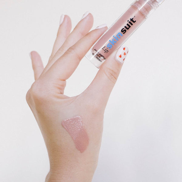 Hand holding SkinSuit Lip SPF 30 | Skin Authority with a swatch of glossy, sheer nude lip color applied on the back of the hand, showcasing skincare and lip protection benefits.