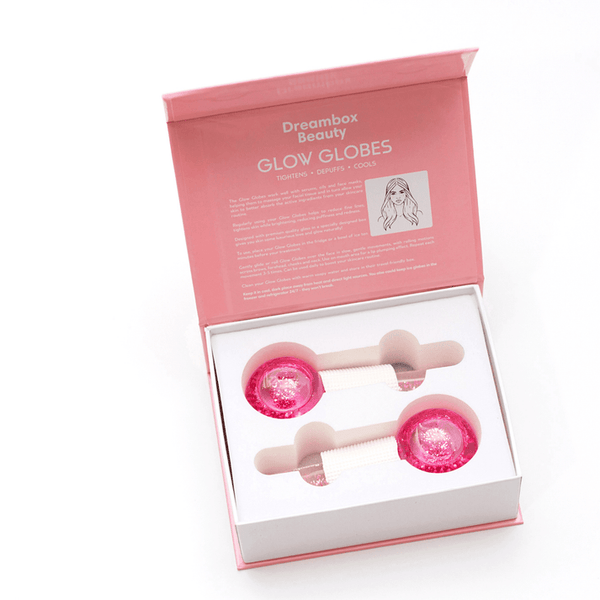 Open pink box containing two pink ice rollers with white handles designed for skincare use, featuring the product name Glow Globes [Ice Roller for Face] | Dreambox Beauty printed inside the lid.