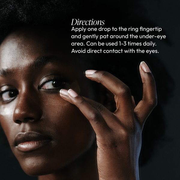 Close-up of a person gently applying Eye Lift Serum (formerly Emergency Eye Lift) | Circadia under their eye with the ring fingertip, demonstrating skincare application directions.