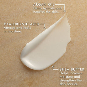 Close-up of a creamy textured skincare product highlighting key ingredients: argan oil for hydration, hyaluronic acid for moisture retention, and shea butter to enhance skin moisture and strength, featuring Hand Cream | Moroccanoil.