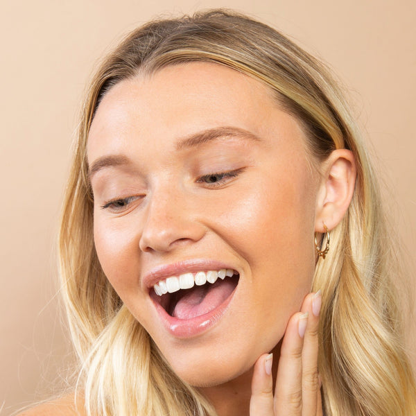Smiling blonde woman with natural makeup showcasing well-defined eyebrows, highlighting the effect of Eyebrow Pencil | Chella on a smooth, glowing complexion.