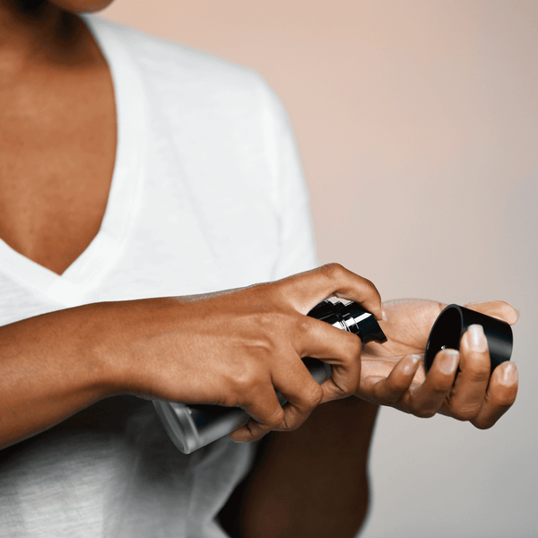 Person dispensing a clear serum from a black pump bottle into their hand, highlighting Night Serum | Althaea Skin for skincare use.