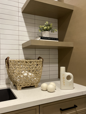 Wool Dryer Balls | L'AVANT Collective displayed on a modern kitchen counter next to a woven basket, white detergent bottle, and minimalistic decor for a clean, wellness-inspired laundry setup.