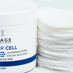 Jar of CLEAR CELL salicylic clarifying pads | IMAGE Skincare next to a stack of white textured skincare pads for exfoliating and clarifying skin.