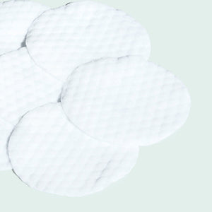 Close-up of textured white skincare pads arranged on a light surface, designed for use as CLEAR CELL salicylic clarifying pads | IMAGE Skincare.