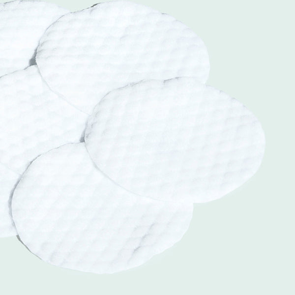 Close-up of textured white skincare pads arranged on a light surface, designed for use as CLEAR CELL salicylic clarifying pads | IMAGE Skincare.
