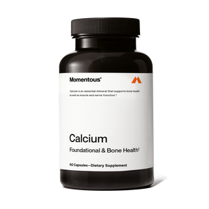 A black bottle of Calcium dietary supplement capsules with a white label highlighting its support for bone, muscle, and nerve health.