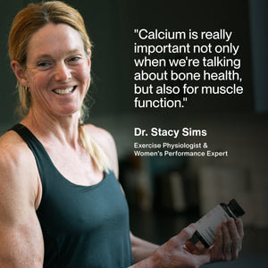 Woman holding a bottle of Calcium supplements smiling, with quote from Dr. Stacy Sims about Calcium’s importance for bone health and muscle function.