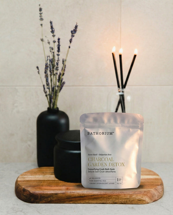 Charcoal Garden Detox Crush | Bathorium pouch displayed on a wooden tray with black vessels lavender stems and lit incense in a calm spa setting
