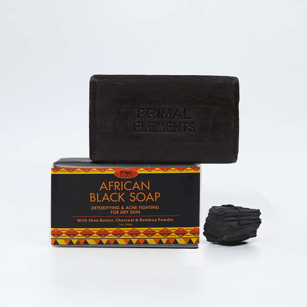 Luxury African Black Soap | Primal Elements bar with charcoal piece, highlighting natural skincare benefits for detoxifying and fighting dry skin.