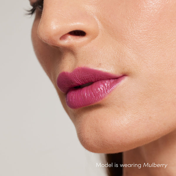 Close-up of a woman’s lips wearing ColorLuxe Hydrating Cream Lipstick | Jane Iredale in a rich mulberry shade, showcasing smooth, hydrated texture and vibrant color.