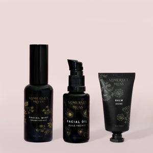 Core Collection Kit | Somerset Moss featuring facial mist, facial oil, and balm in elegant black packaging with floral detailing for skincare and body care wellness.
