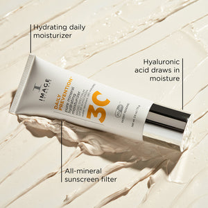 Tube of DAILY PREVENTION Pure Mineral Hydrating Moisturizer SPF 30 | IMAGE Skincare on creamy textured surface, highlighting hydrating daily moisturizer, hyaluronic acid, and all-mineral sunscreen filter.