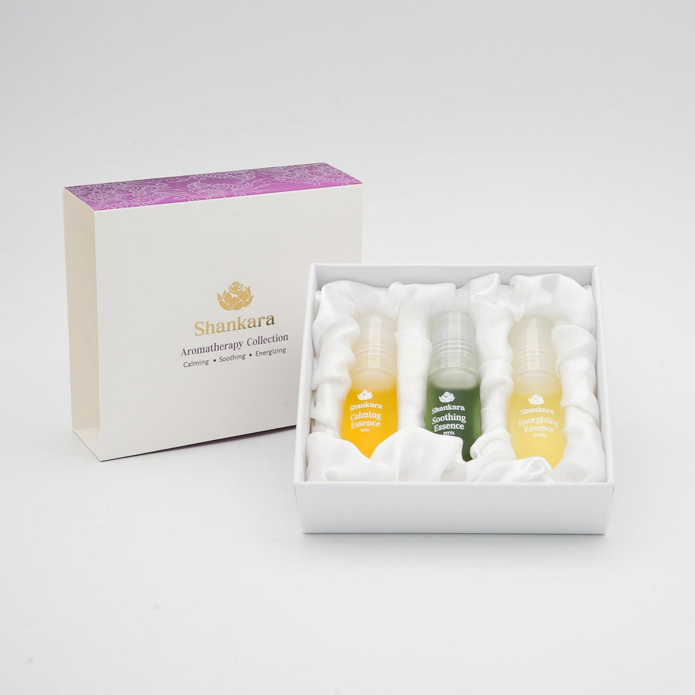 Three small frosted bottles containing yellow, green, and light yellow essences labeled Calming Essence, Soothing Essence, and Energizing Essence from Aromatherapy Collection | Shankara for skincare and wellness.
