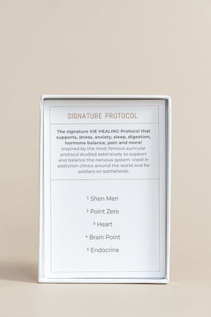 The Foundation - 24K Gold Ear Seed | Vie Healing packaging showing the Signature Protocol details that support stress, anxiety, sleep, digestion, hormone balance, and pain relief.