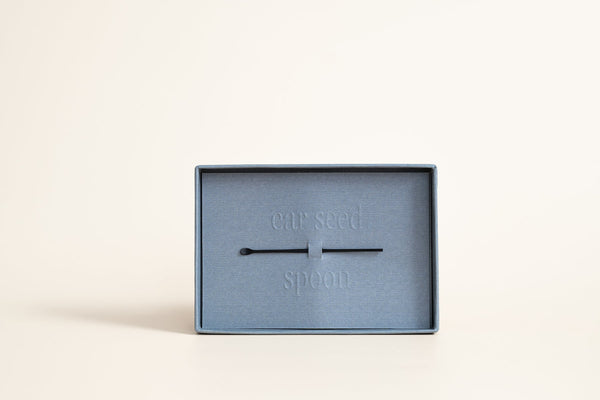 Calm Cool Collected - 24K Gold Ear Seed | Vie Healing displayed in a minimalist blue box with a small metal tool on a neutral background, highlighting wellness and recovery tools.