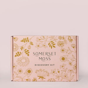 Discovery Kit | Somerset Moss box with elegant floral illustrations in gold on a soft pink background, designed for skincare and wellness product sampling.