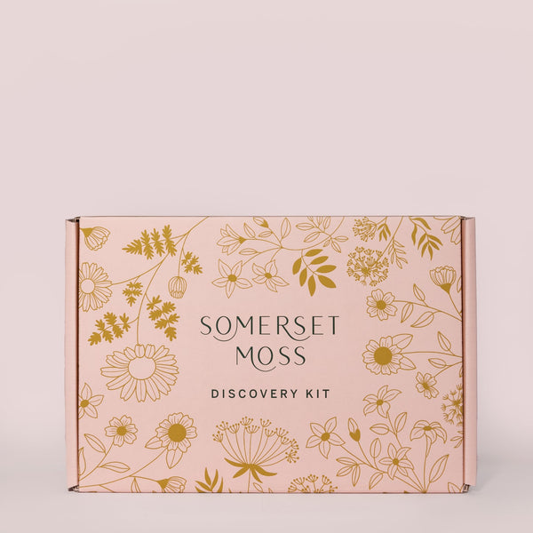 Discovery Kit | Somerset Moss box with elegant floral illustrations in gold on a soft pink background, designed for skincare and wellness product sampling.