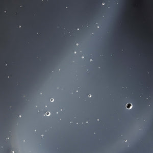 Elixir | Omorovicza shown as clear liquid with suspended bubbles, highlighting its smooth texture in a skincare context.