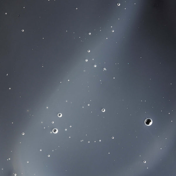 Elixir | Omorovicza shown as clear liquid with suspended bubbles, highlighting its smooth texture in a skincare context.