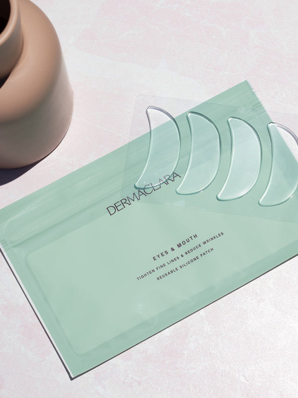 Clear silicone patches shaped for eyes and mouth wrinkle reduction displayed on a pastel green package, featuring SiliconeFusion™ Eyes & Mouth Patches | Dermaclara for skincare and wellness.