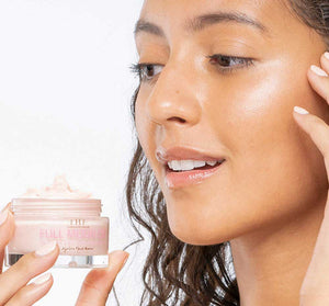 Close-up of a woman holding a jar of Full Moon Dip® Iridescent Illumination Ageless Facial Mousse with Peptides + Retinol | Farmhouse Fresh, showcasing radiant, glowing skin.