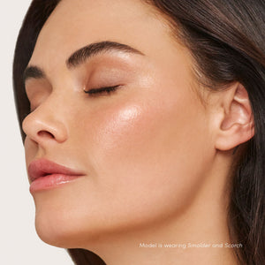 Close-up of a woman with smooth, glowing skin and subtle rosy highlights on her cheeks, showcasing the natural radiant finish of Glow Time Blush Stick | Jane Iredale.