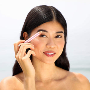 Woman with smooth skin applying makeup near her eyebrow using the Highlighter Pencil | Chella in a soft natural light setting.
