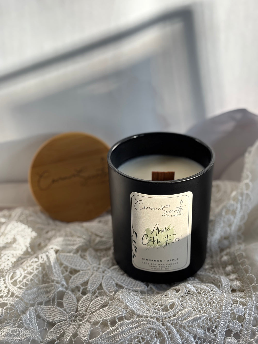 Lit Soft Crackling Wood Wick Candle | CommonScents in a sleek black container with a Wine Barrel scent label, showcasing a cozy and elegant ambiance for wellness and relaxation.