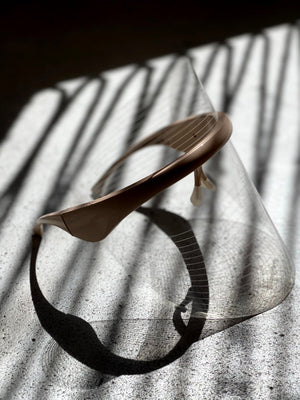 LED Light Therapy Visor | Vie Healing displayed on a textured surface with striped shadows, highlighting its sleek design as a wellness device for skincare and recovery.