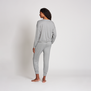 A woman standing barefoot wearing a striped jogger sleep set viewed from the back, showcasing the relaxed fit and comfortable design of the Jogger Sleep Set - 2PC | Lemon.