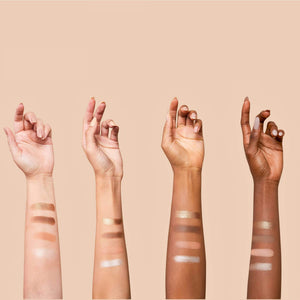 Four arms of different skin tones display swatches of neutral shades from the La Vie Neutral Eyeshadow Palette | Chella against a beige background.