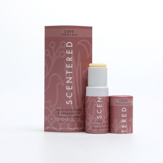 Love Therapy Balm | Scentered in a pink tube and matching box with rose, patchouli, and cedarwood, designed for skincare and wellness use.