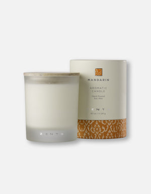A frosted glass aromatic candle with a wooden lid next to elegant packaging featuring a mandarin-inspired design, showcasing the Aromatic Candle | Zents.