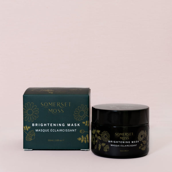 Brightening Mask | Somerset Moss in a dark green jar and matching box with gold floral accents, showcasing a premium skincare product for skin brightening and wellness.