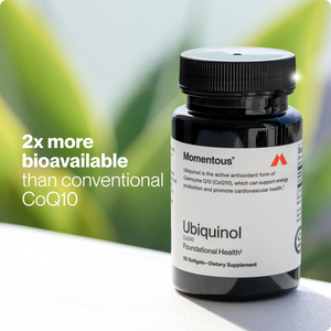 Bottle of Ubiquinol dietary supplement by Momentous with text highlighting it is twice as bioavailable as conventional CoQ10, set against a green blurred background.