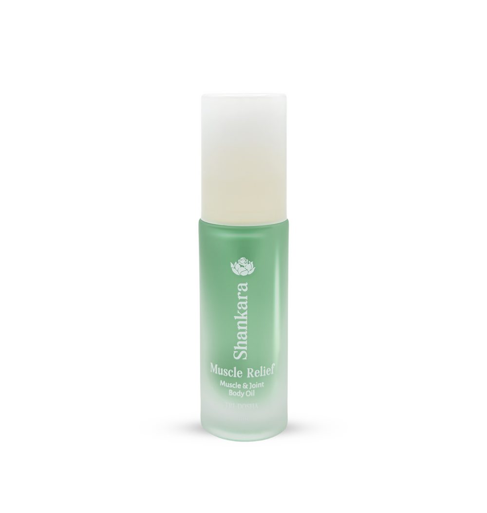 A green frosted glass bottle of Muscle Relief Oil | Shankara, designed for muscle and joint body care, featuring a white spray cap and minimalist text branding.