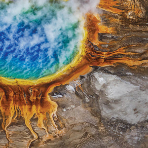 A vibrant natural thermal pool with vivid blue water surrounded by yellow and orange mineral deposits, evoking the essence of Yellowstone 8oz Candle | The Beauty of Hope.