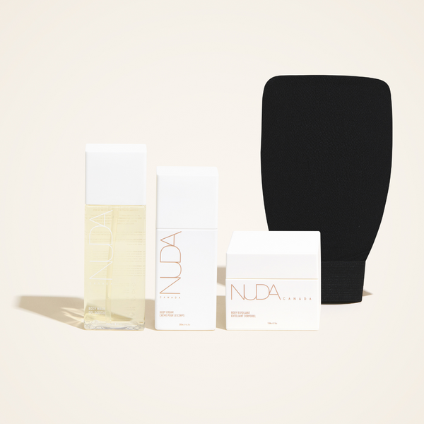 Set of skincare products including a clear bottle, white containers, and a black exfoliating mitt displayed together, highlighting the Exfoliating Mitt | NUDA for body care and wellness.