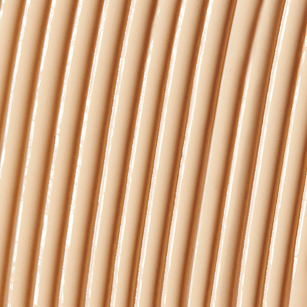 Close-up texture of a smooth, creamy beige skincare serum applied in parallel lines, representing Solarglow™ Mineral Serum Sunscreen | NUDA for a radiant, protective finish.