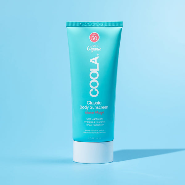 Classic Body Organic Sunscreen Lotion SPF 50 - Guava Mango | COOLA in a turquoise tube against a light blue background, featuring organic skincare designed for lightweight hydration and sun protection.
